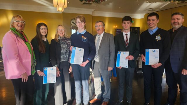 Rotary members with Youth Competition Winners smiling at camera.